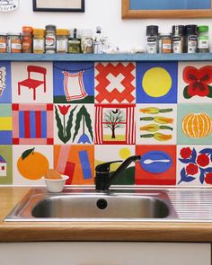 a kitchen sink with colorful tiles on the wall