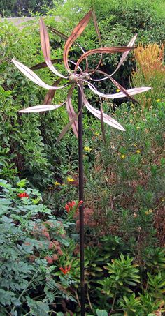 a metal sculpture sitting in the middle of a garden