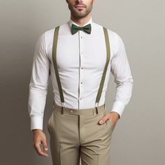 a man in a white shirt and green bow tie is posing for the camera with his hands on his hips