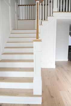 a white staircase with wooden handrails in a house