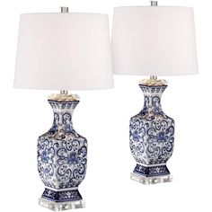 two blue and white vases with lamps on them