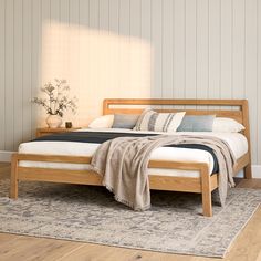 a bed sitting on top of a wooden floor next to a white and blue blanket