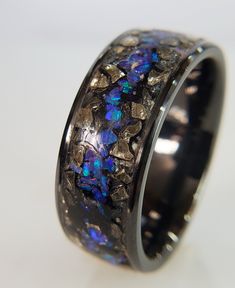 "engagementFor me rings, though small, can carry great meaning, inspiration, and memories! I view them as a vehicle to highlight beautiful material such as German glass glitter and precious and semi-precious stones. ✦ HOW IT'S MADE: - I add layers of material until the inlay is built higher than the walls of channel.  - Then, I grind and sand with 80 to 10,000 grit sandpaper to create a smooth surface. - With my lathe at the high speed of 3,200 rpm I apply diamond polishing grits of 5,000, 10,00 Opal Ring Wedding, Promise Ring Proposal, Black Tourmaline Ring, German Glass Glitter, Blue Opal Ring, Ring Proposal, Opal Wedding Rings, Black Stones, Ring Wedding Band