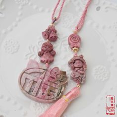 "This accessory features natural rhodonite pendants with cute themes. The pendants in one row are bell, angle and Chinese character \"Fu(福)\". And ones in other row are candy and girl with a pink tassel. The soft pink tone creates a sweet and fresh style and is perfect for someone with a girly heart! This tassel accessory is very suitable for hanging on bags, car rearview mirrors, or any corner of the room, enhancing a classic atmosphere in daily life. For lovers of Hanfu or cheongsam, it is als Handmade Pink Jewelry For Everyday, Pink Amulet Necklace For Gift, Pattern Lock, Rego Park, Chinese Pendant, Flora Pattern, Cute Themes, Pink Tassel, Keychain Bag