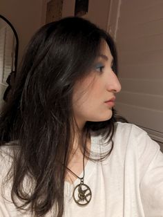 a woman with long black hair wearing a white shirt