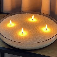 four lit candles sitting on top of a tray