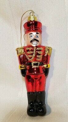 a red and black nutcracker ornament on a white background