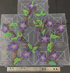 a piece of art made out of perforated mesh with purple flowers on it