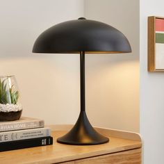 a black lamp sitting on top of a wooden table