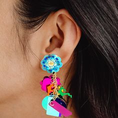 Looking for a fun and fashionable way to add some personality and sparkle to any outfit? Look no further than these fidget-friendly earrings! With so many fun styles to choose from, each pairing has its own unique flair. The designs are created from layers of sequins that move freely from a center point stud, creating a mesmerizing effect that's sure to turn heads. These earrings are perfect for situations where you wouldn't want to risk losing more valuable items. And with their affordable price point, they're a great way for parents to let their little ones add some style without breaking the bank. Whether you're going out dancing or just running errands, these earrings will steal the spotlight and have you feeling carefree as they flash sparkles in all directions. Be noticed wherever yo Playful Jewelry With Matching Earrings For Party, Fun Colorful Dangle Earrings, Colorful Fun Dangle Earrings, Whimsical Blue Earrings For Party, Handmade Multicolor Plug Earrings For Party, Trendy Multicolor Dangle Plug Earrings, Fun Drop Earrings For Pierced Ears, Multicolor Pierced Earrings For Party, Trendy Multicolor Flower Earrings For Party