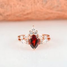 Gorgeous vintage inspired garnet ring made of 14k rose gold over 925 solid sterling silver, making a simple but elegant statement piece. This ring is perfect to wear as engagement ring, promise ring, or birthstone ring. Main Stone: Garnet Stone Creation: Natural (untreated) Color: Red Shape: Teardrop/ Pear Gem size: 7 x 9 mm Carat Weight: 1.7 ct. (approx.) Hardness: 8.5 (Mohs scale) ►Accented with simulated diamonds (CZ). ►Sold as set. ►Please be aware that plated jewelry can wear off over time, Red Ruby Ring In 14k Rose Gold, Ruby Ring In 14k Rose Gold With Round Shape, Red 14k Rose Gold Rings For Anniversary, Red 14k Rose Gold Jewelry For Anniversary, Red 14k Rose Gold Ring, Rose Gold Pear-shaped Ruby Jewelry, 14k Rose Gold Jewelry With Red Gemstone, Gemstone Engagement Ring, Garnet Engagement Ring