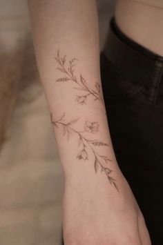 a woman's arm with a flower tattoo on the left side of her wrist