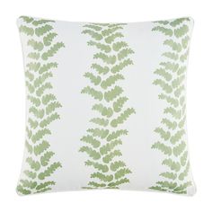 a green and white pillow with leaves on it