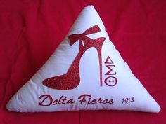 a white pillow with a red high heel shoe on the bottom and delta fierce 1915 written on it