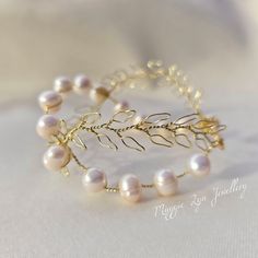 This Handmade Freshwater Pearl Bracelet is an exquisite piece of jewelry perfect for any special occasion. Its chunky pearls and gold leaf design add a touch of elegance and uniqueness to any bridal or wedding jewelry collection. The bracelet is intricately crafted with genuine crystals, freshwater pearls, and handcrafted gold leaves which make it stand out from the rest.  The bracelet comes in a beautiful gold cuff design that enhances its beauty even more. It is made from high-quality material Handmade Elegant Pearl White Bracelets, Pearl White Bangle Bracelets For Wedding, Pearl White Bangle For Wedding, Elegant Handmade Wedding Bracelets, Pearl Bangle Bracelets For Anniversary, Pearl Bangle Bracelet For Anniversary, Handmade Gold Pearl Bracelet For Wedding, Elegant Handmade Bracelets As Bridesmaid Gift, Elegant Handmade Bracelets For Bridesmaids