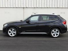 a black bmw suv parked in front of a building