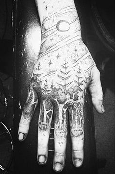 a person's hand with tattoos on it