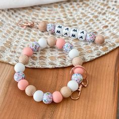 a wooden beaded bracelet and keychain sitting on top of a table