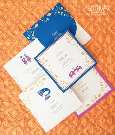 the wedding stationery is laid out on an orange tablecloth with blue envelopes