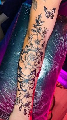 a woman's arm with flowers and butterflies on it