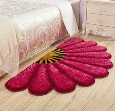 a bed room with a neatly made bed and a pink rug on the floor next to it