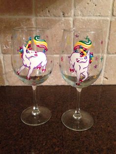 two wine glasses with unicorns painted on them