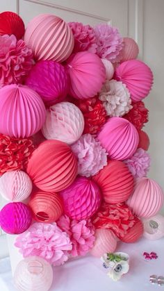 pink and red paper lanterns are arranged on the table