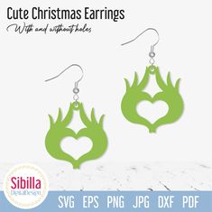 pair of earrings with green leaves and heart cutout on them, in the shape of a