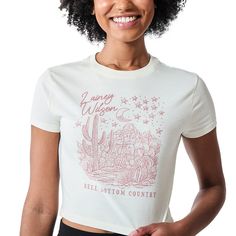 Celebrate your love for country music with this women’s sand Lainey Wilson crew neck short sleeve baby tee. Adorned with a charming image of cacti under a crescent moon and stars, this tee captures the spirit of “Bell Bottom Country.” Lainey Wilson’s name elegantly graces the top of the design, making it a standout piece for any fan. Made from soft cotton rib knit, it offers a comfortable and flattering fit. Easy to care for, simply machine wash it on cold with like colors and tumble dry on low heat for lasting wear. Relaxed Fit Tops For Country Concerts, Fitted Graphic Print Tops For Country Concerts, Fitted Tops For Summer Country Concerts, Bell Bottom Country, Scene Women, Lainey Wilson, Desert Scene, White Crew Neck, Sleeve Packaging