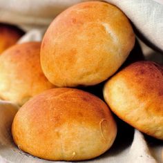 a pile of bread rolls sitting on top of a white cloth