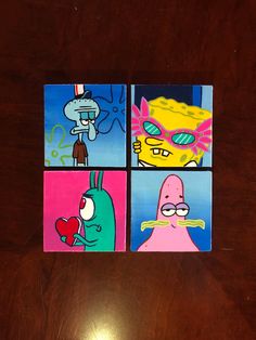 four square pictures with cartoon characters painted on them sitting on a wooden table in front of a computer keyboard