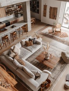 a living room filled with lots of furniture next to a large open floor plan area