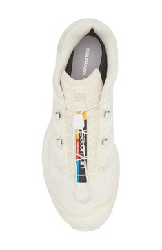 a white sneaker with an insulated sole and laces on the side,