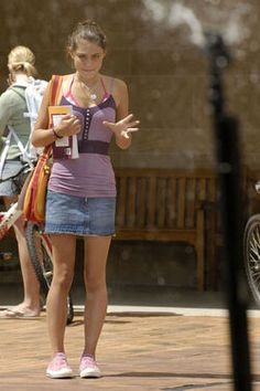 a woman standing on the street with her hand out