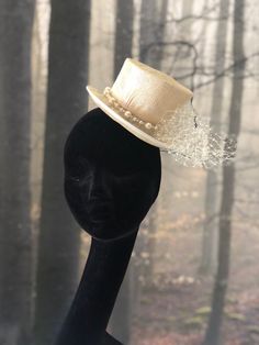 This "Vienna" Mini Hat embodies elegance in every detail. Adorned with a ruched veil and a handmade jewelery chain, this accessory is a style statement. With a double adjustment, using a white rubber band and a traditional comb, it guarantees a secure and comfortable fit. The subtle asymmetry in its height, 9 cm on one side and 8 cm on the other, adds a distinctive touch to its design. Its total diameter of 16 cm provides a balanced proportion. Crafted in the distinctive Sinamay material, this m Elegant Luxury Handmade Mini Hats, Luxury Mini Hat With Feather Trim For Party, Luxury Cream Mini Hats For Weddings, Luxury Elegant Mini Hat With Feathers, Luxury Vintage Mini Hat For Parties, Luxury Fitted Mini Hats For Wedding, Luxury Adjustable Mini Hats For Races, Luxury Chic Adjustable Mini Hats, Luxury Mini Hats With Ostrich Feathers For Wedding