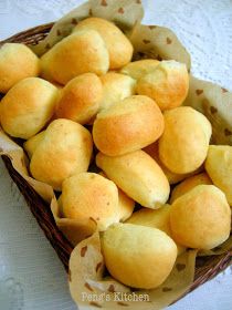 a basket filled with rolls sitting on top of a table next to a white table cloth