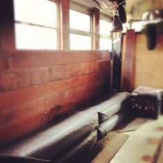 the inside of an old train car with wood paneling and leather seats on it