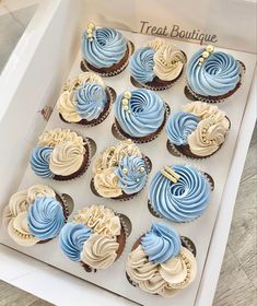 a box filled with blue and white cupcakes