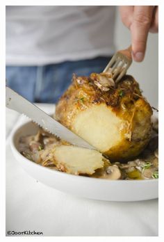 a person is cutting into some food on a plate with a knife and fork in it