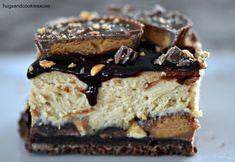 three pieces of chocolate and peanut butter cheesecake on top of each other with drizzle