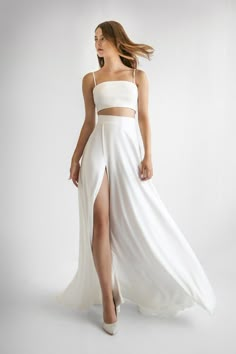 a woman wearing a white dress and high slit skirt