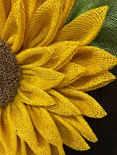 a large yellow flower with green leaves on it