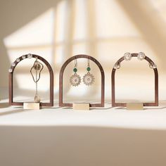 three wooden jewelry stands with earrings on them