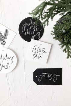 three black and white tags with writing on them next to a christmas tree ornament