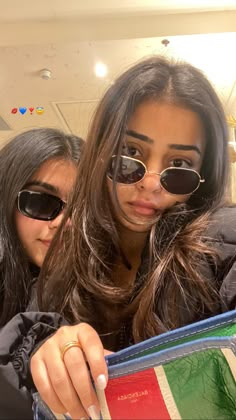 two young women looking at an italian flag purse with sunglasses on their faces and one holding the other in her hand