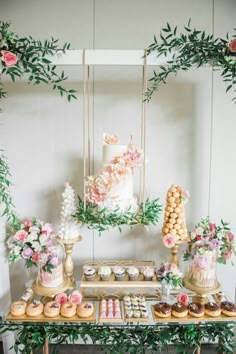 the dessert table is decorated with flowers and greenery