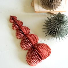 some red and white paper flowers on a table next to an open book ornament