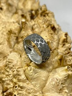 a silver ring sitting on top of a rock