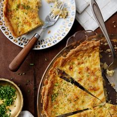 there is a pie on the table with two plates and silverware next to it