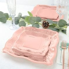 there are pink plates and silverware on the table